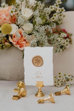 the place cards were placed next to gold cufflinks and flowers in vases