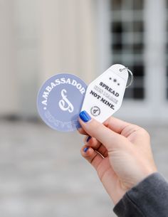 a person holding up a white and blue badge with the word anassada on it