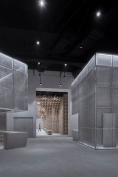 an empty room with white walls and metal mesh partitions on the wall, lighting from above