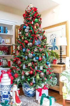 a decorated christmas tree in a living room with presents under it and other holiday decorations