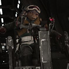 an action figure sitting on top of a chair in a dark space station with lights on