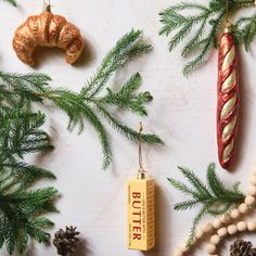 christmas ornaments are hanging on the wall next to pine cones and other decorations, including an ornament