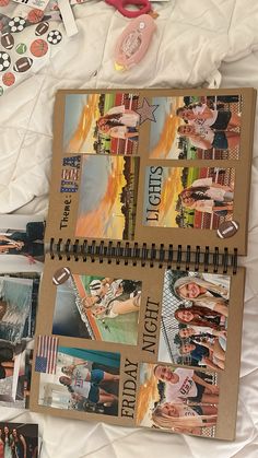 an open book with pictures and stickers on it sitting on a bed next to other items