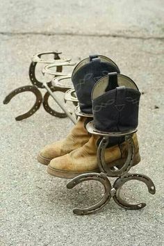 two pairs of boots sitting on top of a metal stand