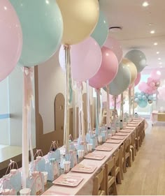 a long table with many balloons and place settings for guests to sit down at it