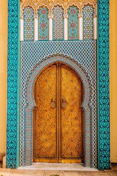 an intricately decorated door in the middle of a building with blue and gold tiles