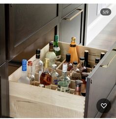 an open drawer in a kitchen filled with bottles