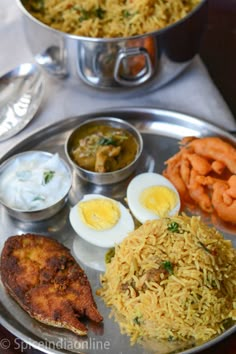 a silver plate topped with rice and fried eggs