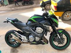 a green and black motorcycle parked on the street