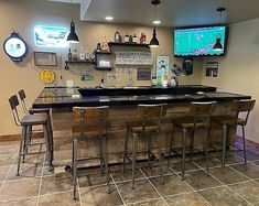 a bar with several stools in front of it and a television on the wall