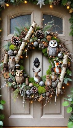 a christmas wreath with owls, pine cones and other decorations on the front door to give it a festive feel