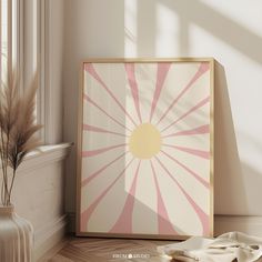 an art print on the wall next to a vase with dried grass in it and a window sill