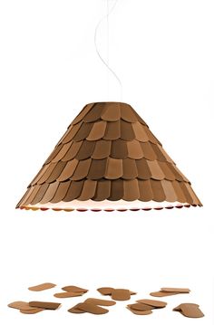 a light that is made out of clay and has leaves on the floor next to it