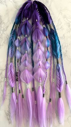 Purple Rain Festival Braids Extensions☔️Ombré royal purple, blue, and lilac hair with black and silver-colored hair charms throughout as well as amethyst-colored glass hanging hair gems 💎 💜 Pull-Through Braids, Fishtail Braids, Bubble Braids, Rope Braids, and Traditional Plaits On a hair tie for easy use. Wrap the loose hair section around a ponytail or bun and secure with a bobby-pin, or braid into your own hair for awesome and easy festival braids. See my instagram @braidsbabes88 for installation tutorials 🥰😻 DisclaimerThis is sold as a single set for a ponytail. If you want 2 separate sets for pigtails as shown in some of the photos, a quantity of 2 must be purchased**There are only 2 in stock, if a single set is purchased, this disclaimer and the listing photos will be updated to r Colourful Braids, Purple Festival Braids, Colorful Braided Hair Extensions, Synthetic Braids Festival, Festival Hair Wigs & Extensions, Synthetic Hair Braids Festival, Braids Fishtail, Braids Extensions, Rope Braids