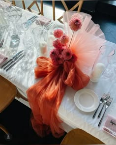 the table is set with flowers and silverware