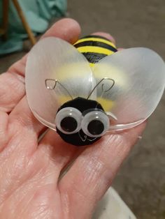 a hand holding a small glass bee on it's palm