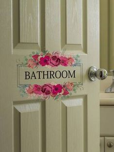 the bathroom door is decorated with flowers and has a sign that says, bath room