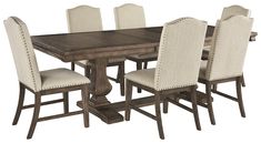 a dining room table and chairs with white fabric upholstered on the backrests