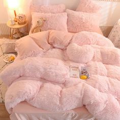 a bed with pink comforters and pillows in a child's bedroom, next to a teddy bear