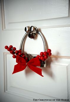 a red bow is hanging on the door handle and it's made out of metal