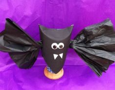 a black paper bag with a bat on it's head and two bags in the shape of bats