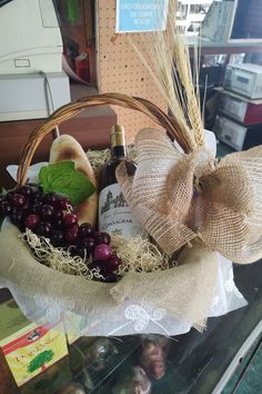 a basket filled with grapes, cheese and wine