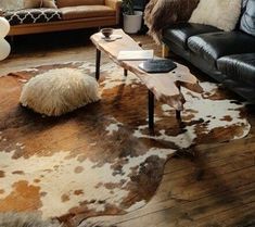 a living room with two couches and a table in front of the couch is an animal print rug