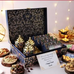 an assortment of desserts and pastries on a table with lights in the background