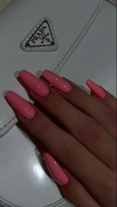 a woman's hand with pink nail polish on it