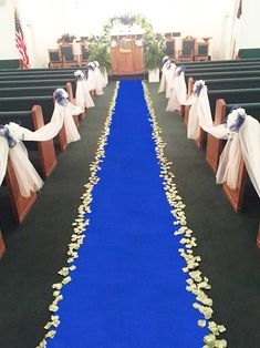 the aisle is decorated with white and blue flowers, ribbons and streamers on either side