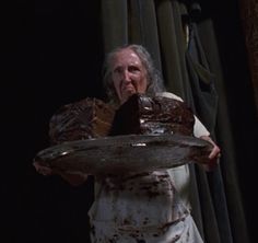 an old man holding a large piece of chocolate cake