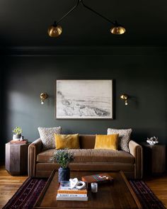 a living room with a couch, coffee table and lamps on the wall above it