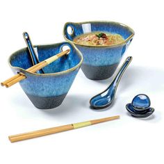 two bowls with spoons and chopsticks on a white surface, next to each other