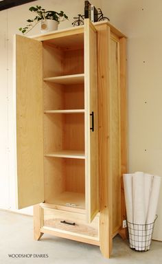 a wooden cabinet sitting next to a potted plant