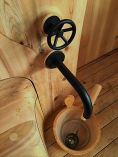 a wooden toilet with a black handle on it