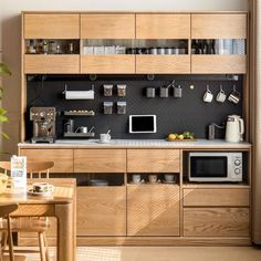 a kitchen with wooden cabinets and appliances on the counter top, along with a dining room table