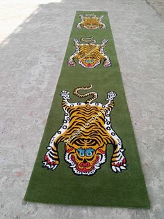 a long green rug with three tigers on it