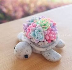 there is a small turtle with flowers on it's back and its shell made out of clay