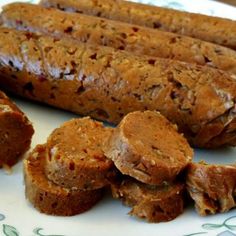 several sausages are on a plate with other food items