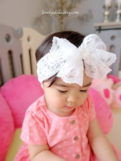 A beautiful lace bow headband suitable for all ages! Bow is approximately 5" wide attached to a 2" wide stretch lace. Offering different kinds of gem at the center of the bow to create a a diverse look.  Currently, photos are showing gem #1 and #2.  ⭐️Please note, gem sizes are different, therefore the result of the overall bow look may be slightly different than in photos. Also, due to the nature of this bow type, the shape/drape may slightly vary as well. Bow may look bigger in photos due to t Cute Adjustable Headband For Wedding, Cute Adjustable Headband For Weddings, Adjustable White Lace Hair Accessories, Cute White Headband With Pink Bow, White Lace Headband For Party, White Matching Headband For Baptism, White Adjustable Hair Accessories, White Hair Accessories With Matching Headband For Baptism, White Lace Party Headband