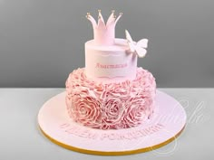 a pink cake decorated with roses and a crown