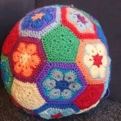 a multicolored crocheted ball sitting on top of a couch