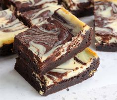 some brownies with white frosting are stacked on top of each other and one is cut in half