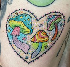 a colorful heart shaped tattoo with mushrooms and stars on it's side, in the shape of a fish