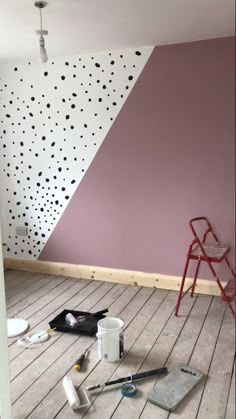 a room that has some paint and tools on the floor in front of an empty chair