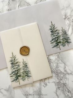 two cards with trees on them and one has a wax stamp