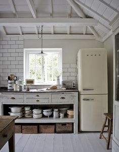 an old fashioned kitchen with white brick walls