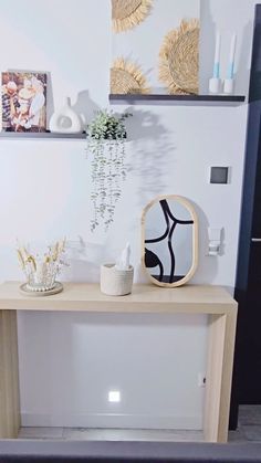 a wooden table with vases and pictures on the wall