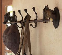 two hats hanging from hooks on a wall next to a pair of shoes and a hat rack