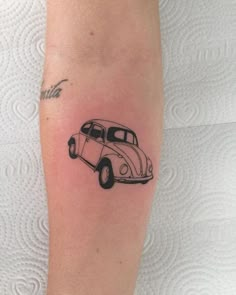 a small black and white beetle tattoo on the right leg, it looks like an old vw bug